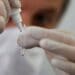 Santiago Webajh, scientist of the Pablo Cassara foundation, puts a drop of reagent in a container during a test of the new "NEOKIT-COVID-19?, developed by a group of Argentine scientists that diagnoses the coronavirus disease (COVID-19) in less than two hours, in Buenos Aires, Argentina May 19, 2020. REUTERS/Agustin Marcarian